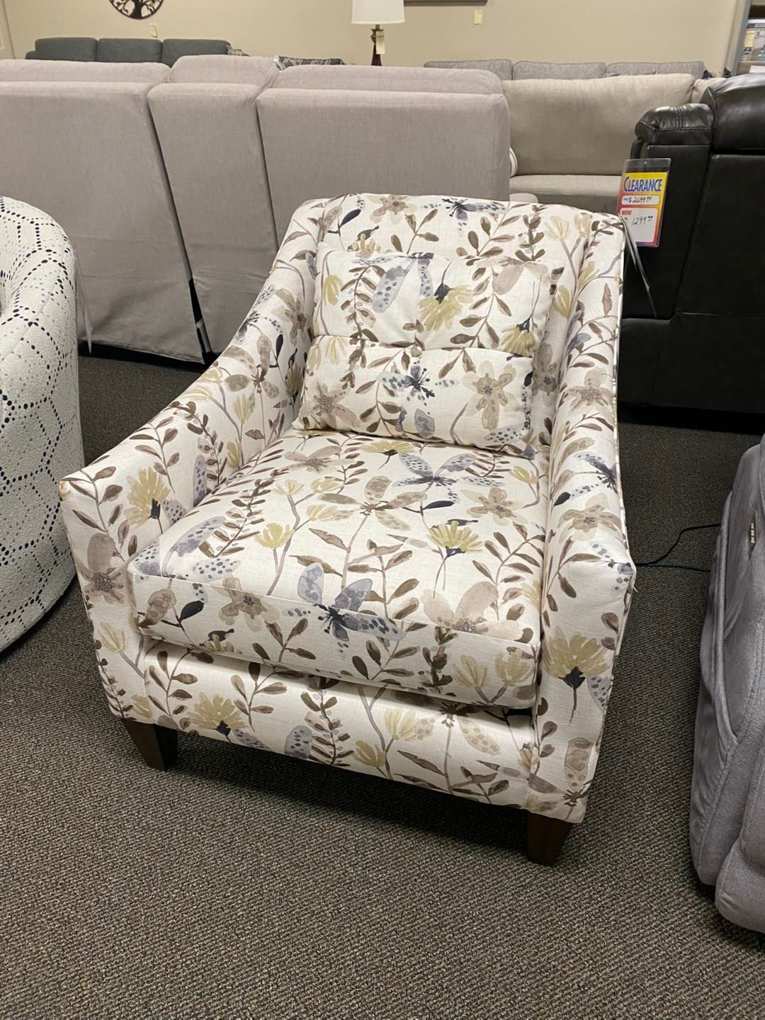 A chair with a floral pattern is sitting in a living room.