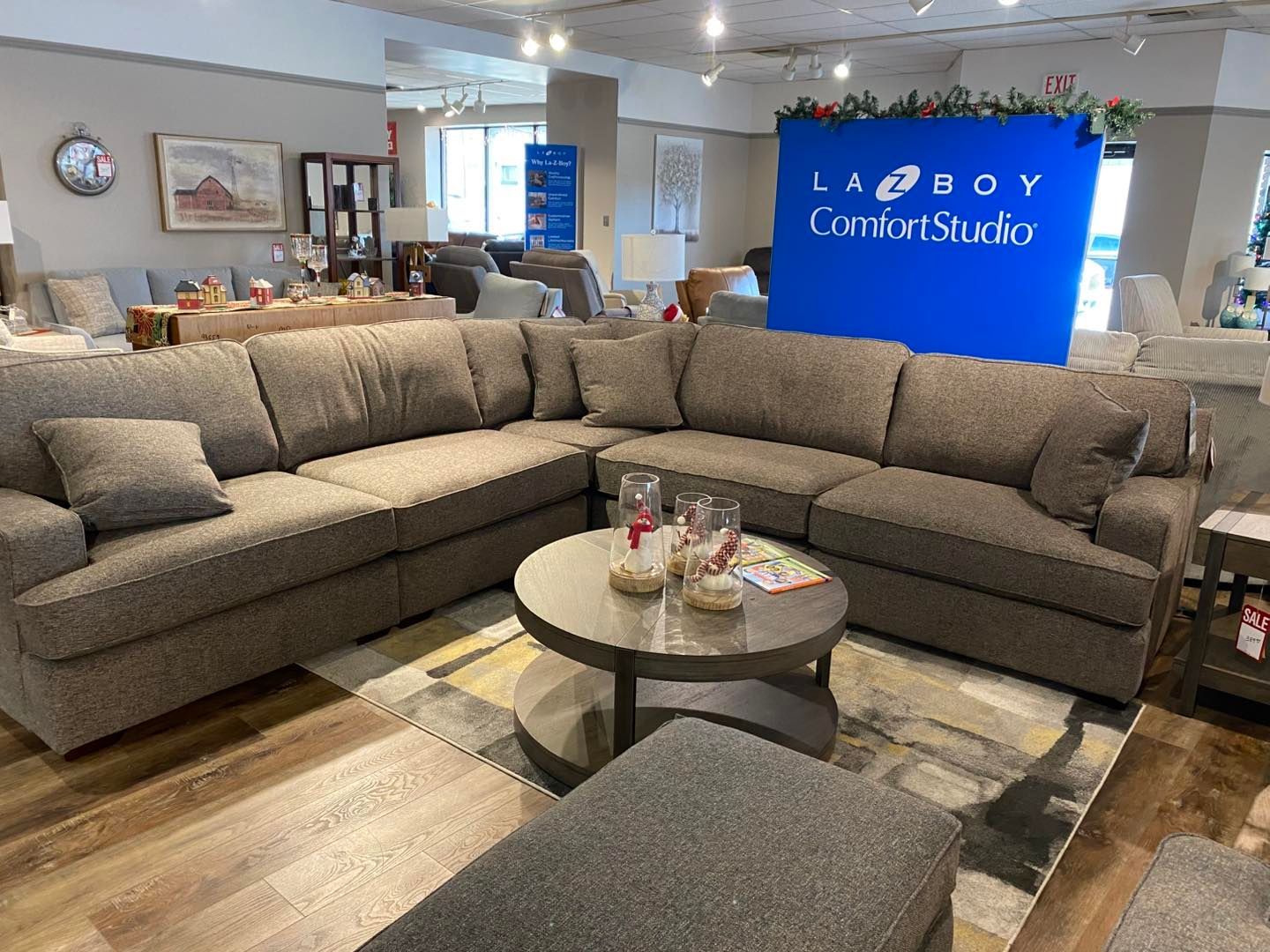 A living room with a large sectional couch and a round coffee table.