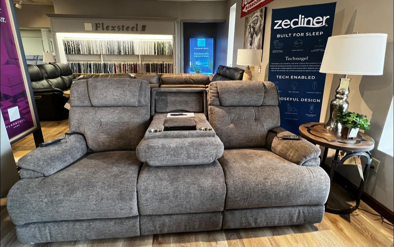 A couch is sitting in a room next to a table and a lamp.