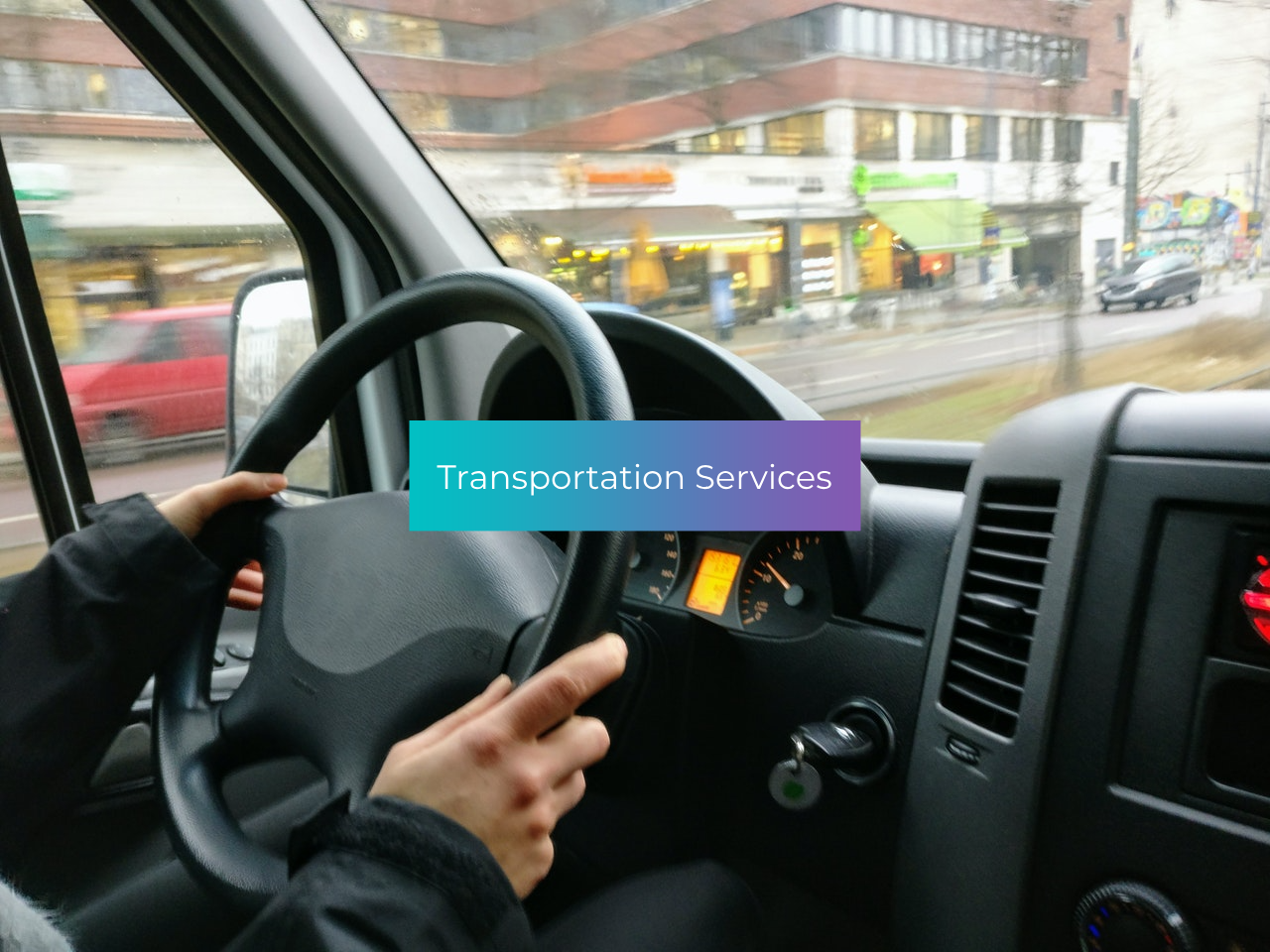 A person is driving a van with a sign that says transportation services