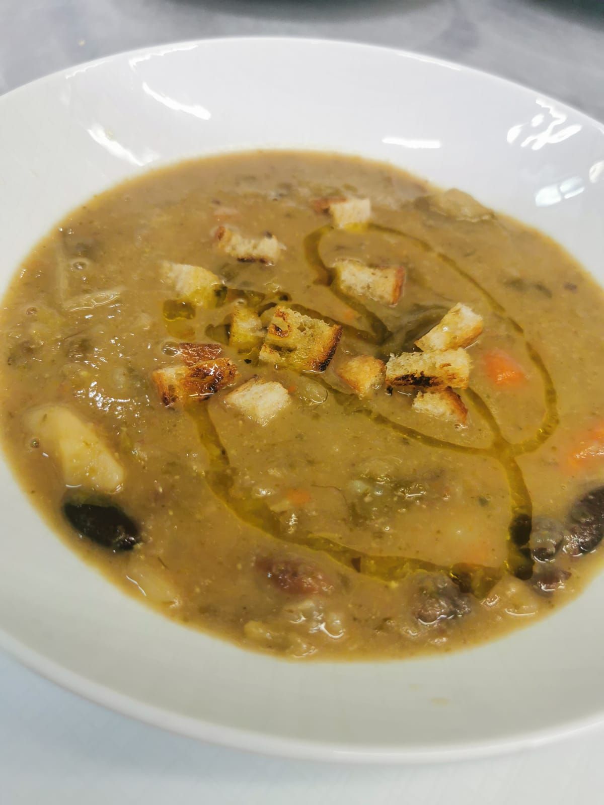 un primo piano di una ciotola di zuppa con sopra dei crostini di pane.