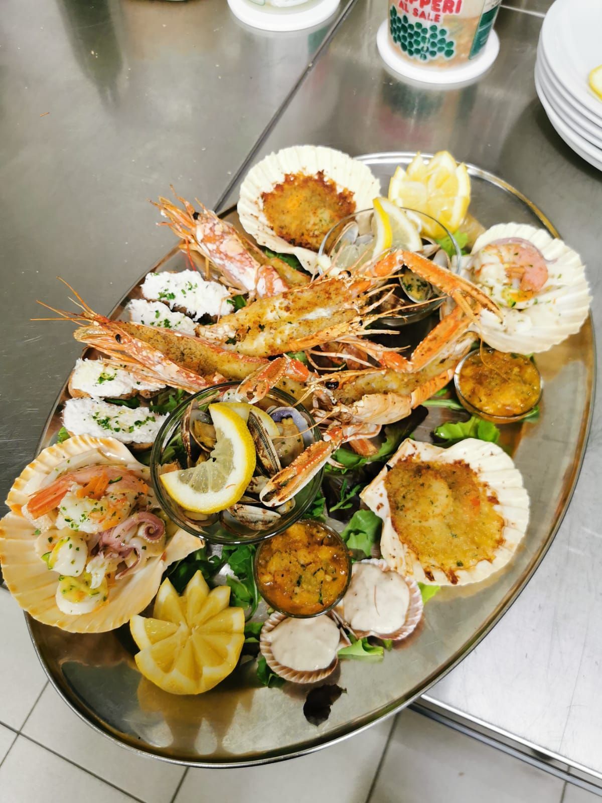 un piatto di frutti di mare con fette di limone su un tavolo.