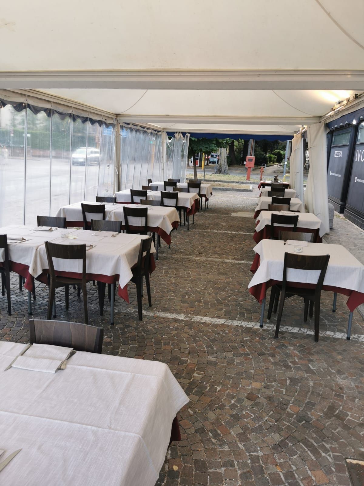 una grande stanza esterna con tavoli e sedie