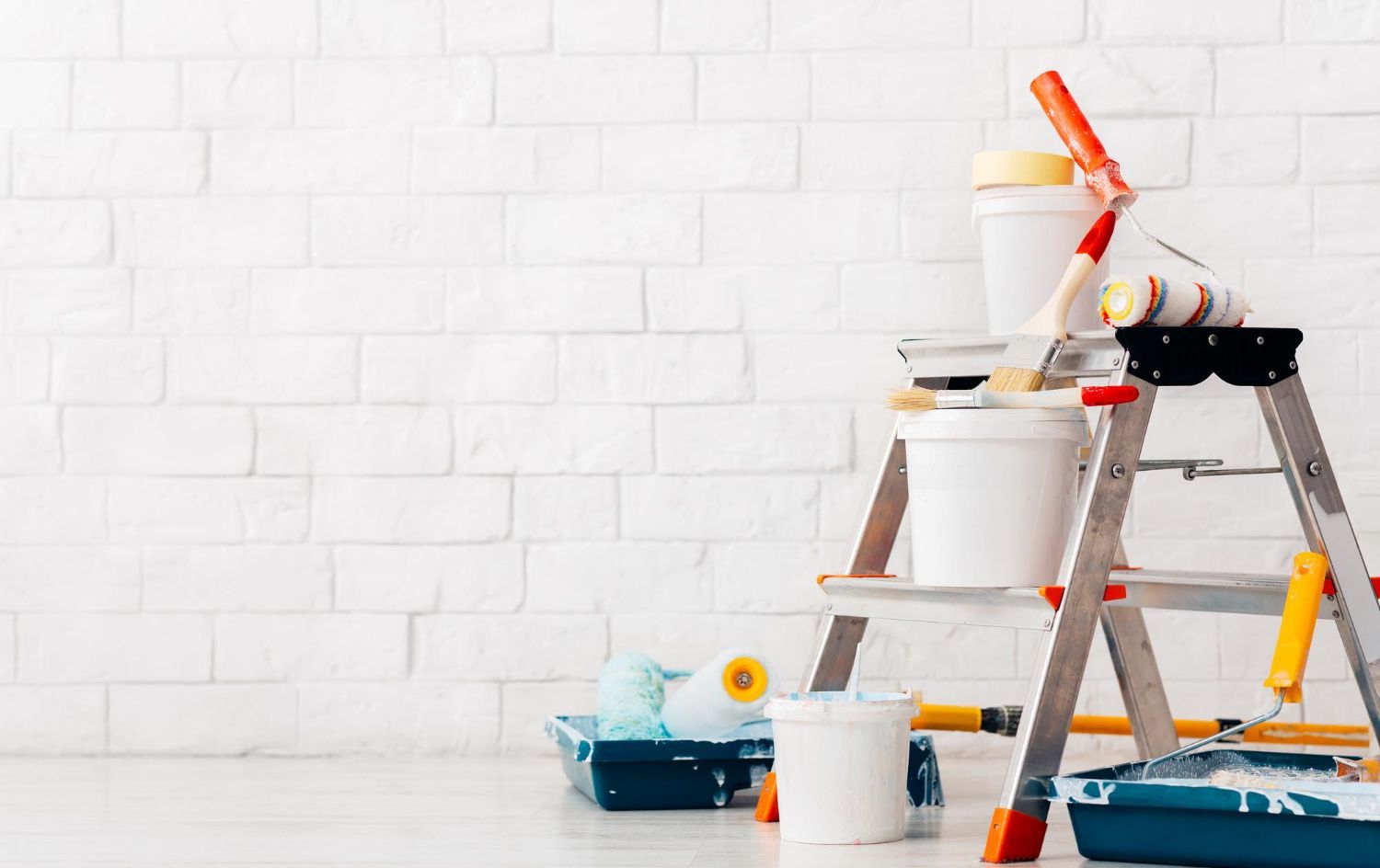 A ladder with buckets of paint and paint rollers on it.