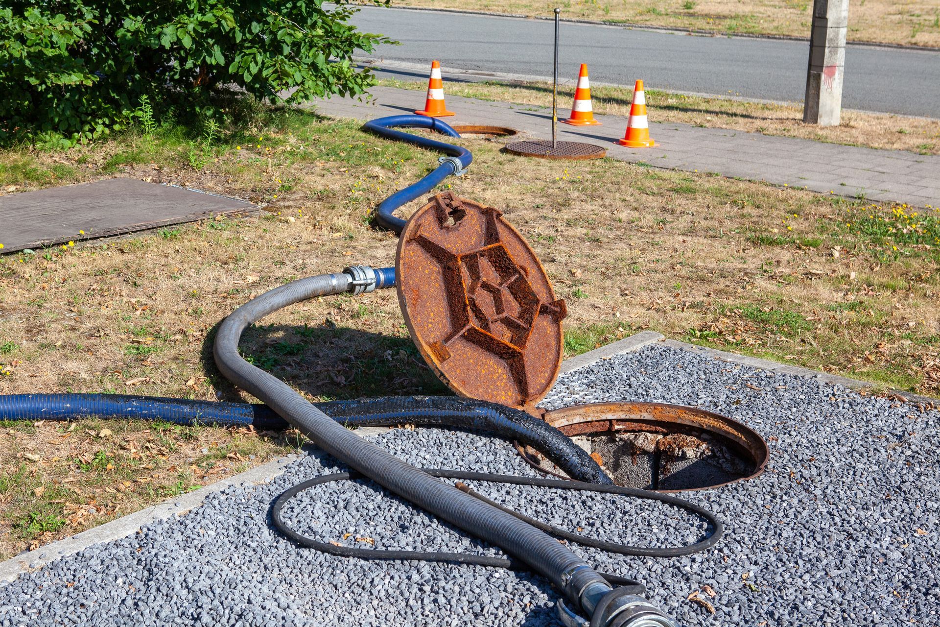 A manhole cover with a hose attached to it.