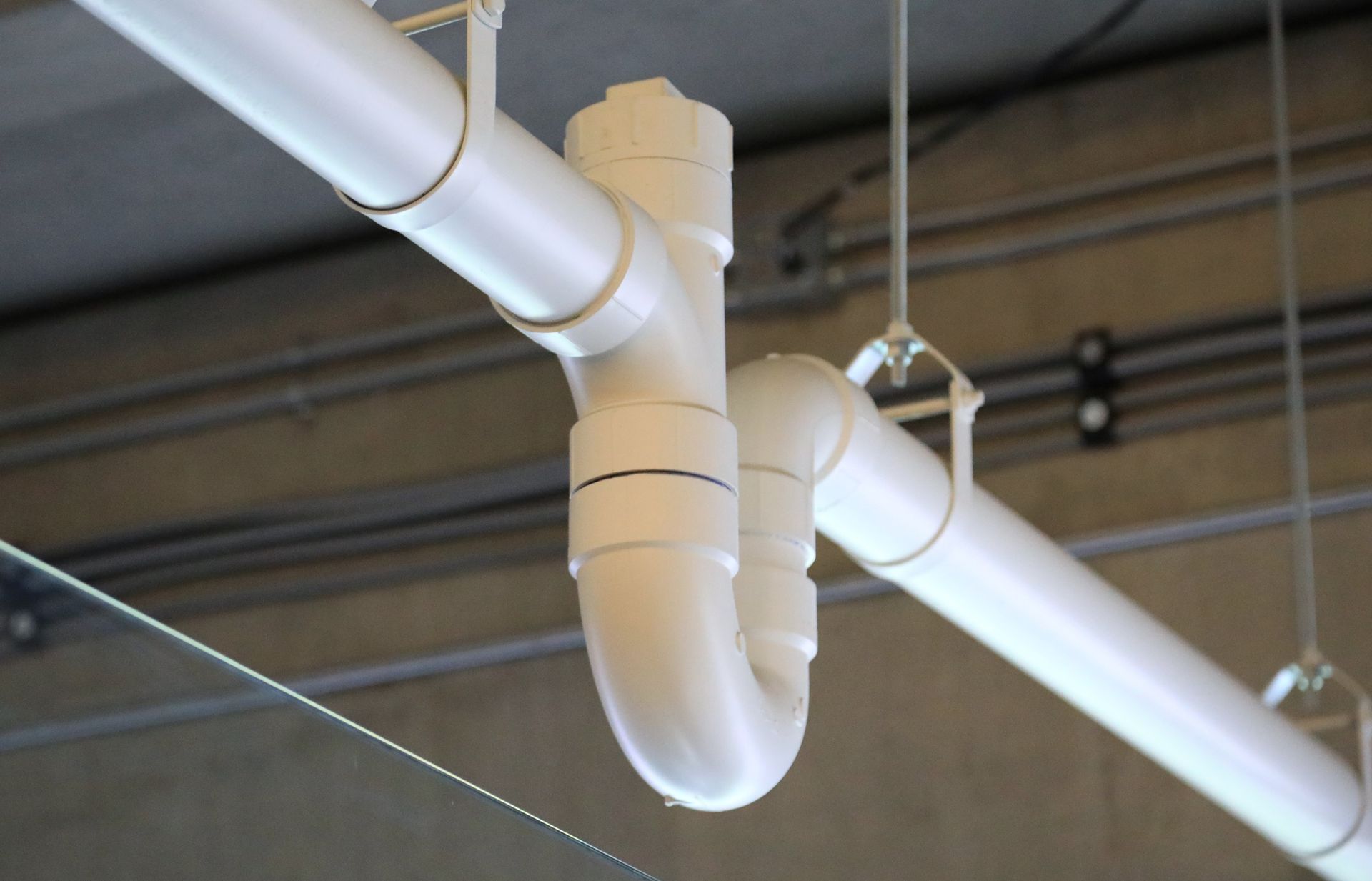 A close up of a white pipe hanging from the ceiling
