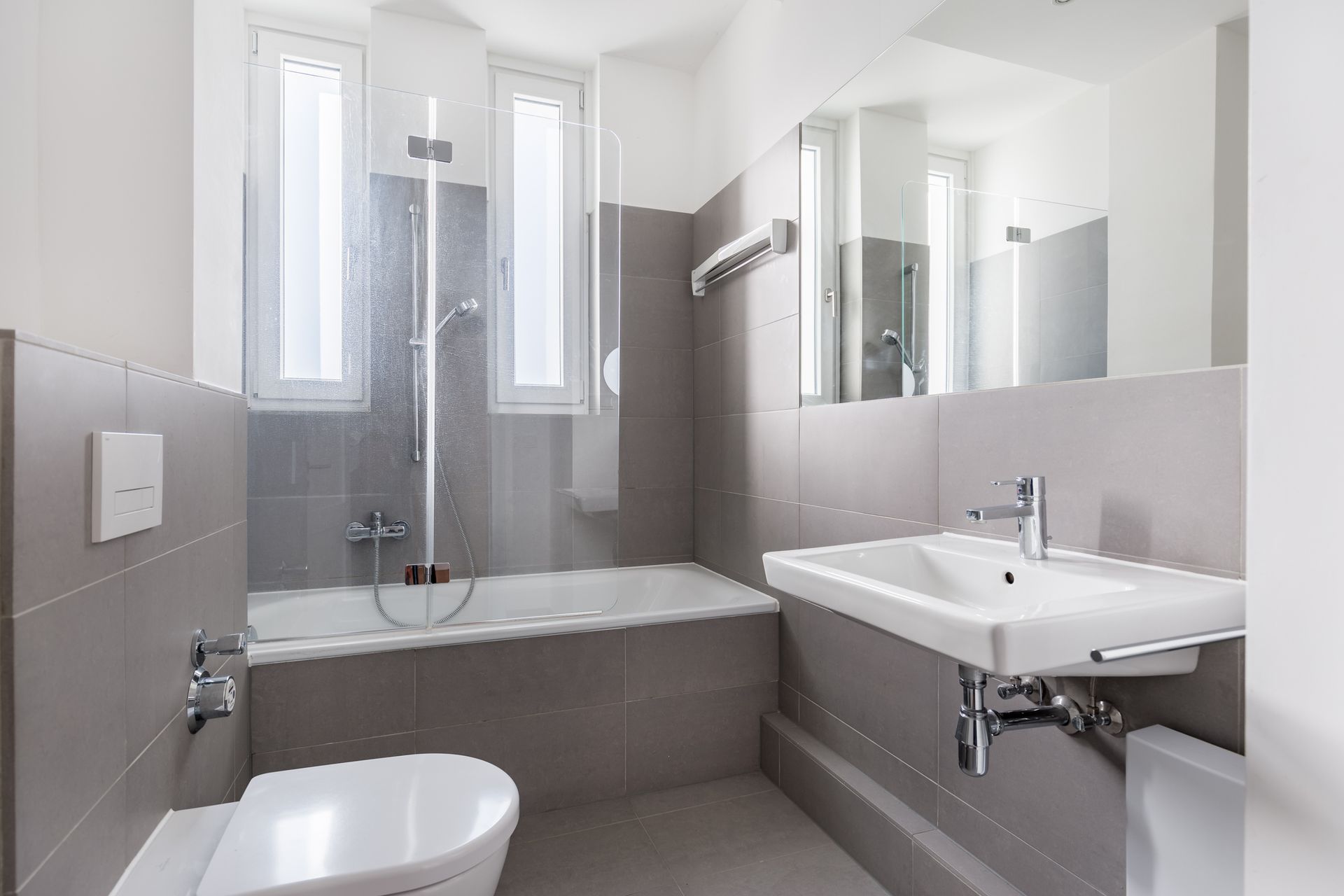 A bathroom with a sink , toilet , bathtub and mirror.
