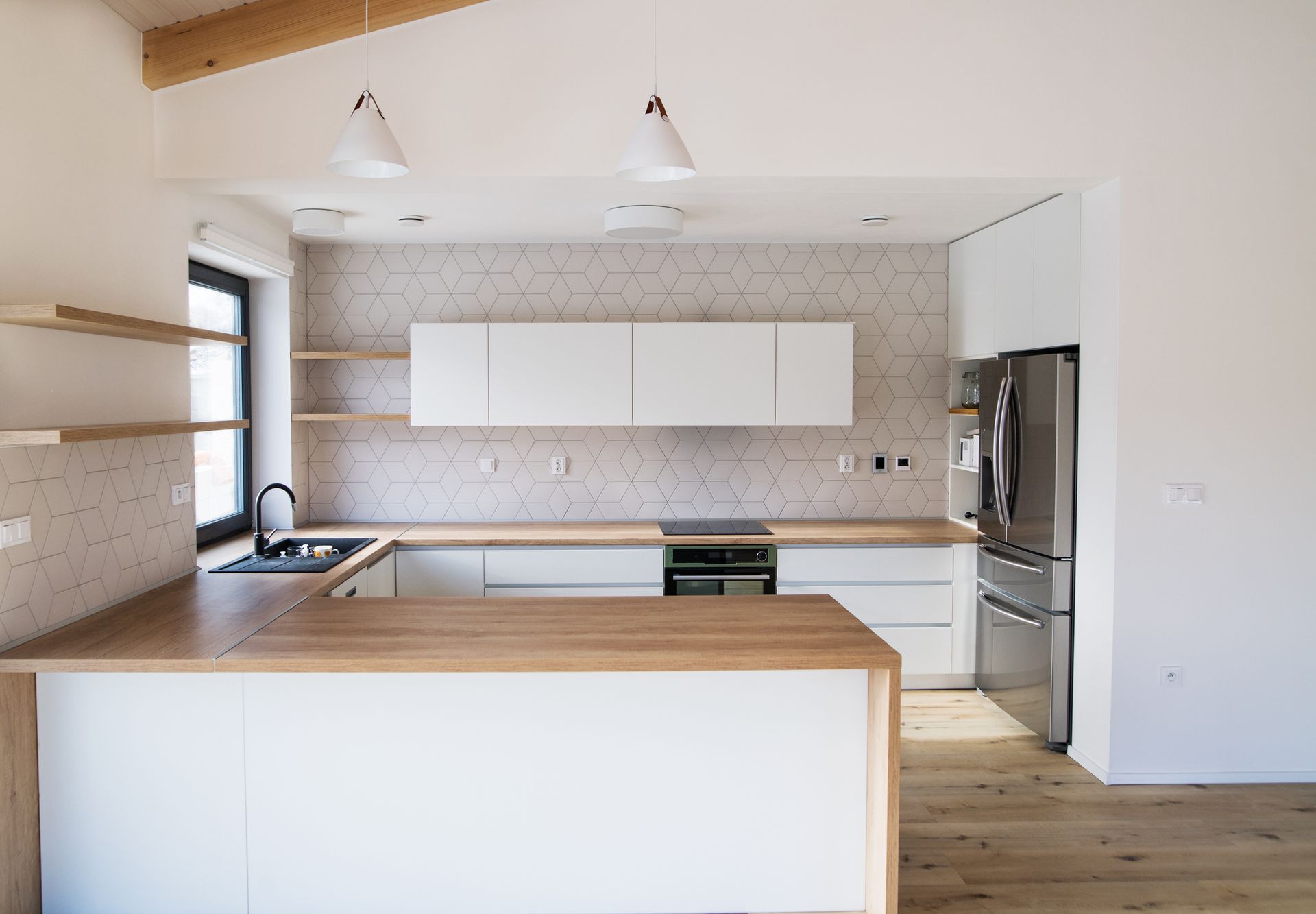 A kitchen with white cabinets and a wooden counter top.