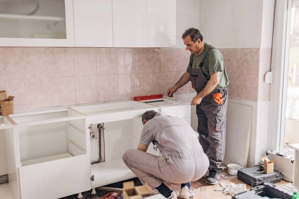 Two men are working on a kitchen remodel.