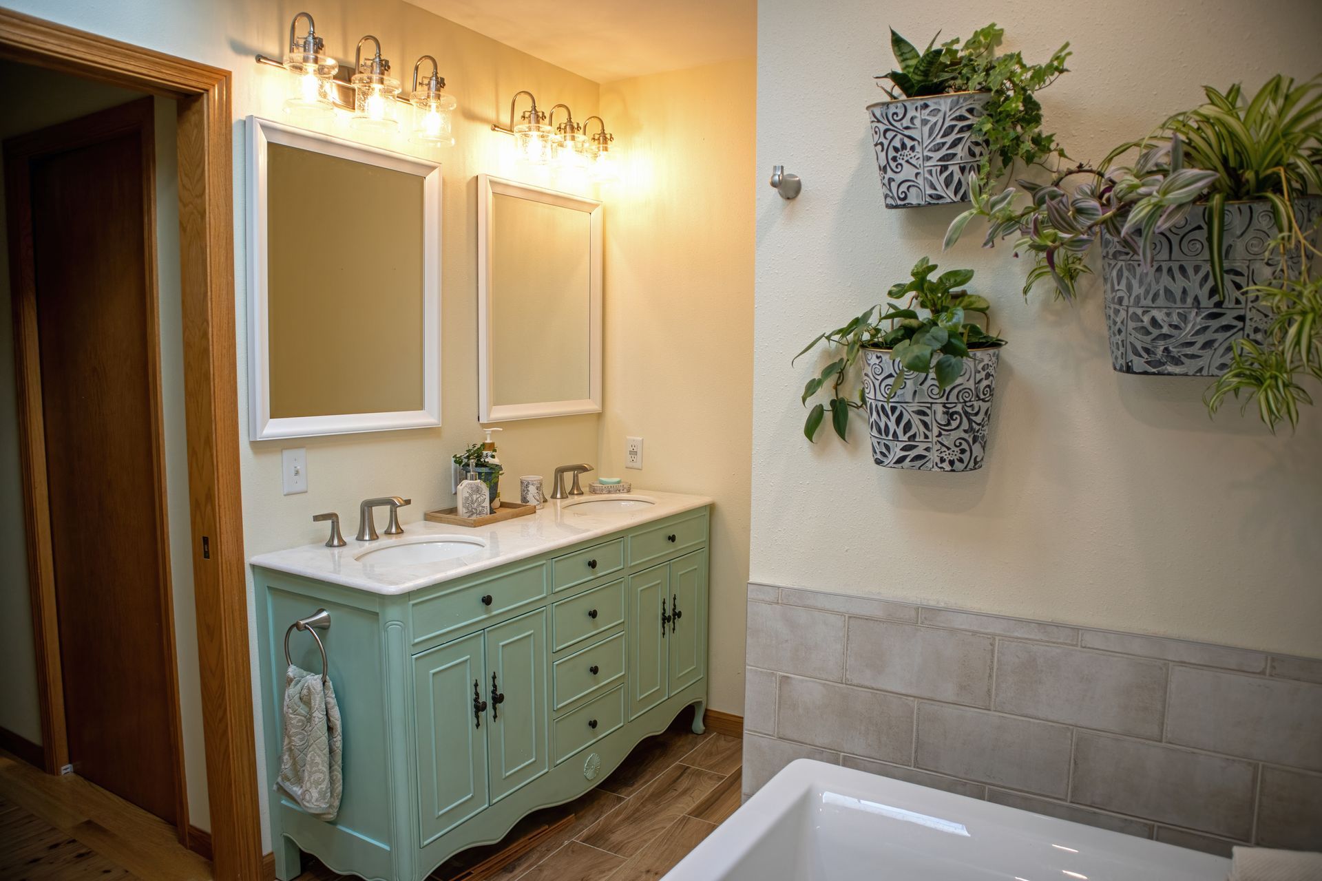A bathroom with two sinks , two mirrors , and a tub.