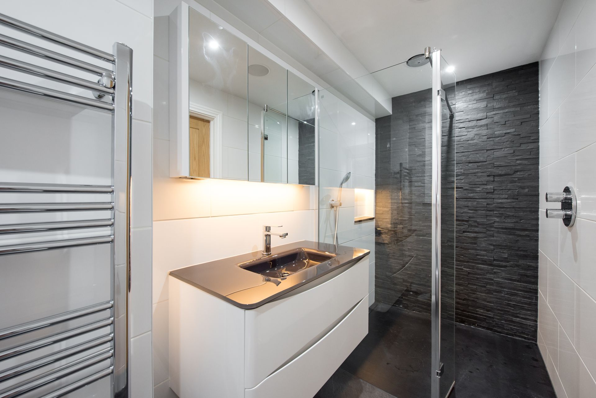 A bathroom with a sink and a walk in shower.