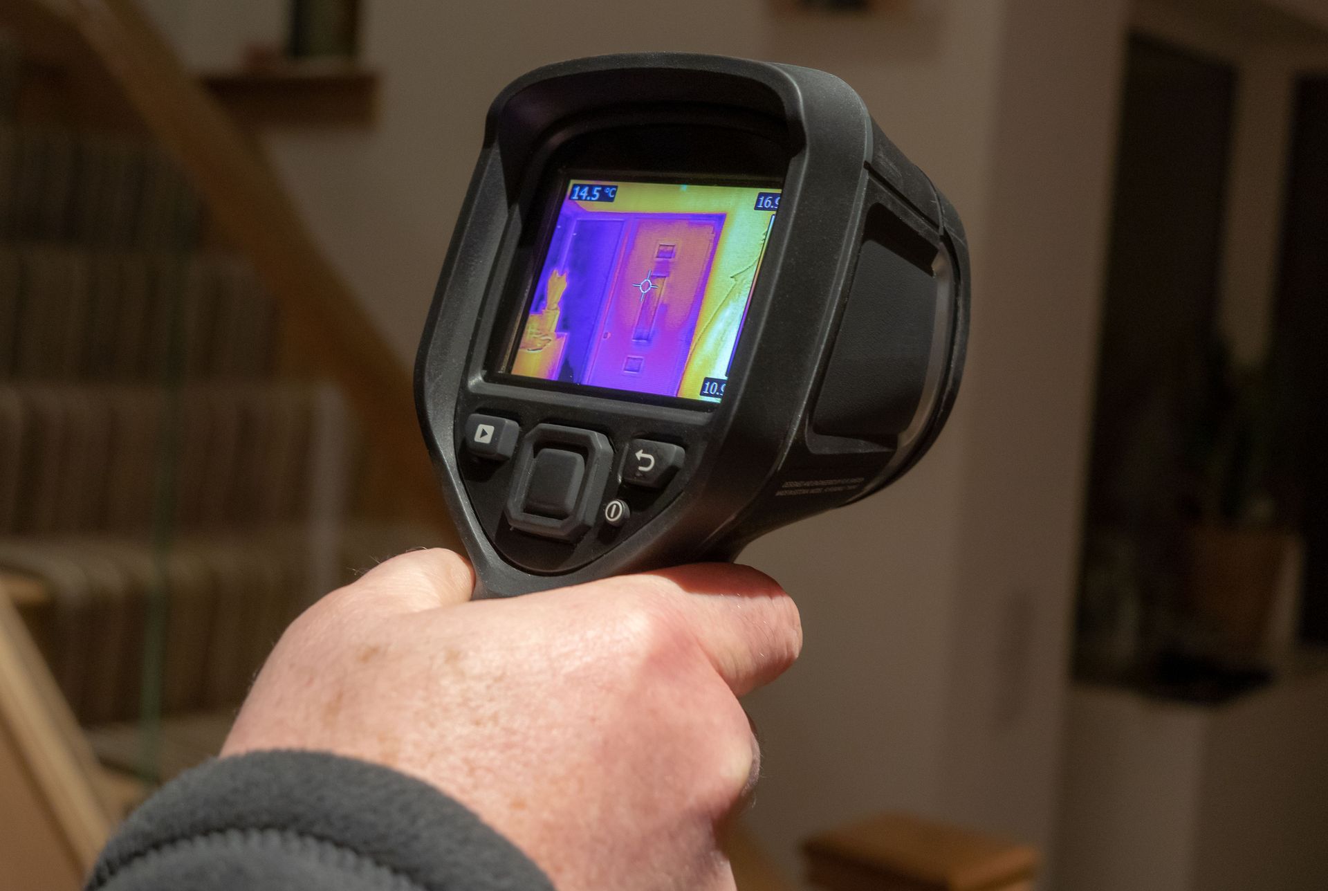 A person is holding a thermal camera in their hand.