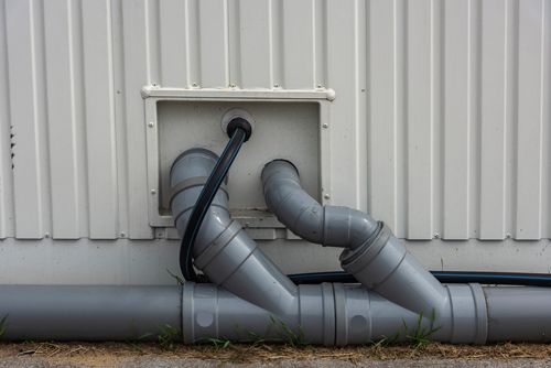 A close up of a pipe on the side of a building.