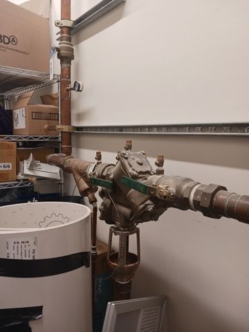 A bunch of pipes are connected to a wall in a room.