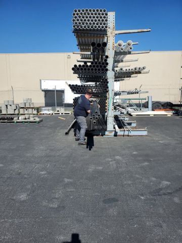 A man standing in front of a stack of pipes