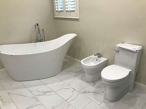 A bathroom with a bathtub , toilet and bidet.