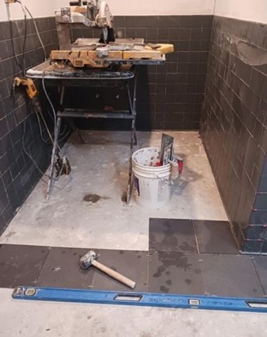 A room with a hammer and a level on the floor.