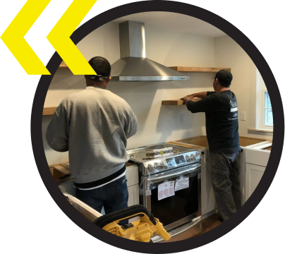 Two men are working on a stove in a kitchen