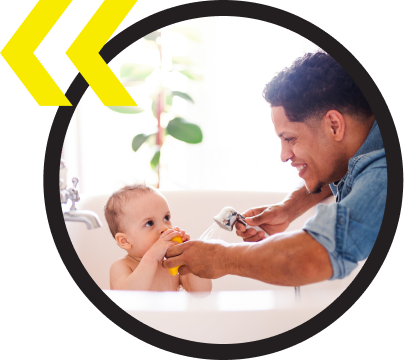 A man is bathing a baby in a bathtub A man is bathing a baby in a bathtub