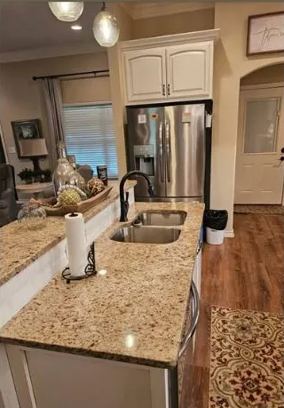 Kitchen with granite countertops, stainless steel appliances, and white cabinets.
