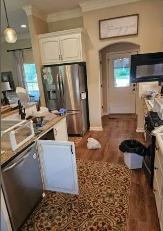 Kitchen with open dishwasher, messy counter, and open cabinet door. Stainless steel refrigerator.