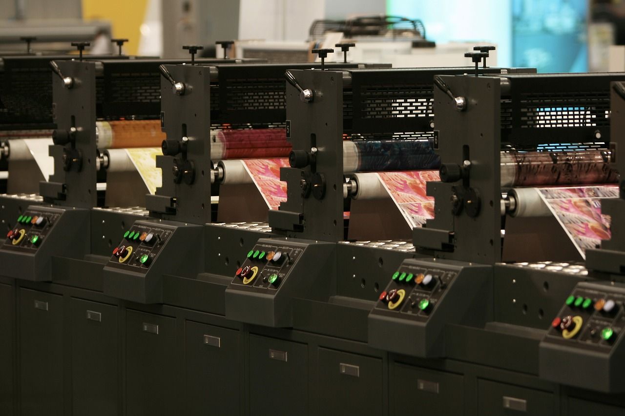 A row of printing machines are lined up in a factory.