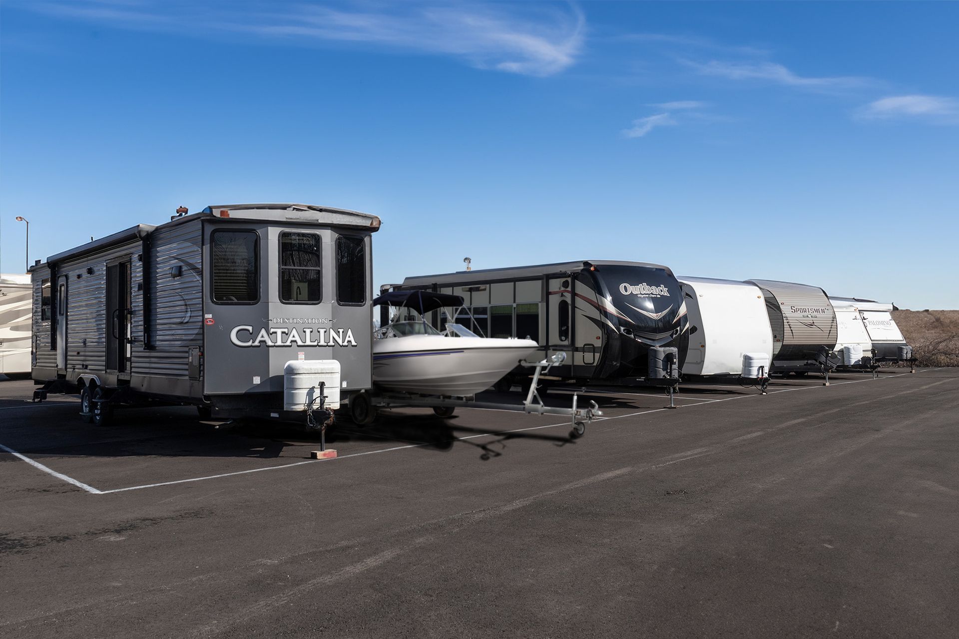 A row of recreational vehicles are parked in a parking lot.