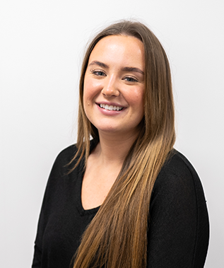 A woman with long hair is wearing a black shirt and smiling.