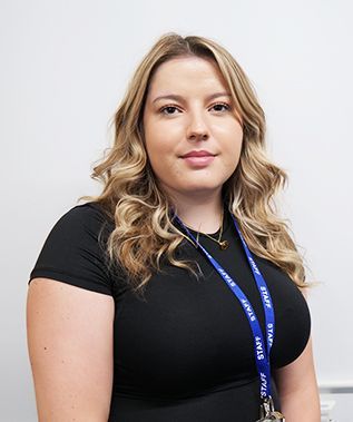 A woman is wearing a black shirt and a lanyard around her neck.