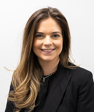 The woman is wearing a black jacket and smiling for the camera.