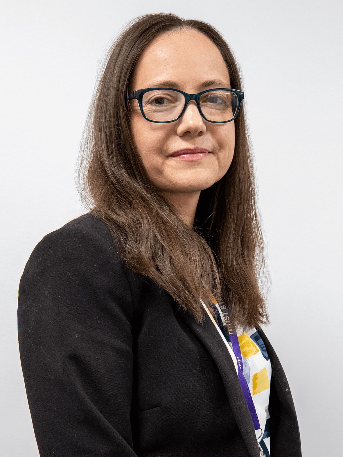 A woman in a blue shirt is smiling for the camera.