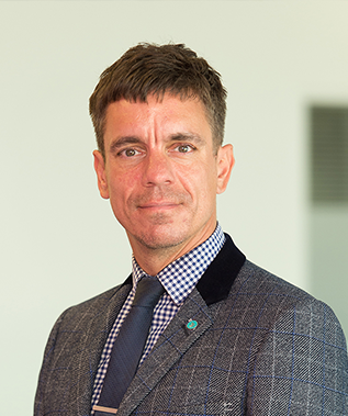 A man in a suit and tie is smiling for the camera.