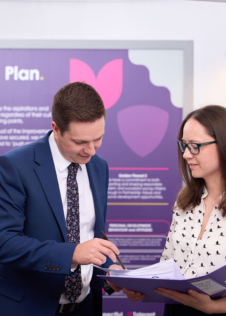 A man and a woman are looking at a clipboard.