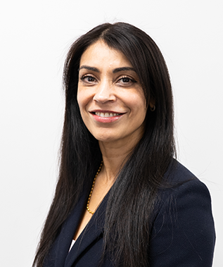 A woman with long black hair is smiling and wearing a blue jacket.