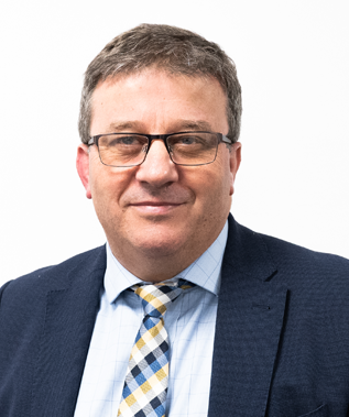 A man in a suit and tie is smiling for the camera.