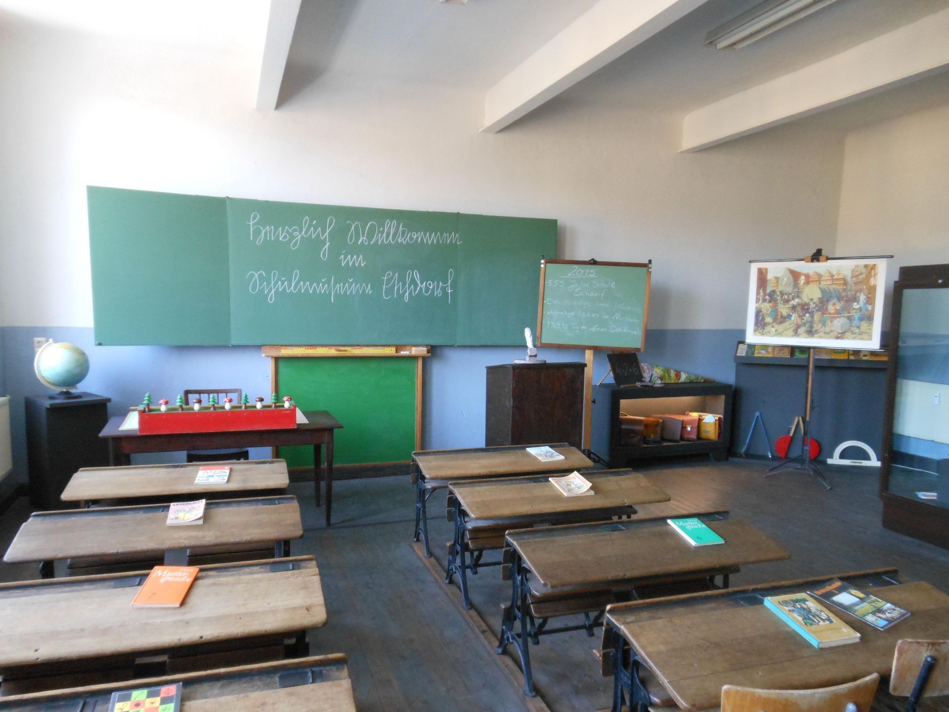 Ein Klassenzimmer mit Holztischen und einer grünen Tafel mit der Aufschrift „Januar“