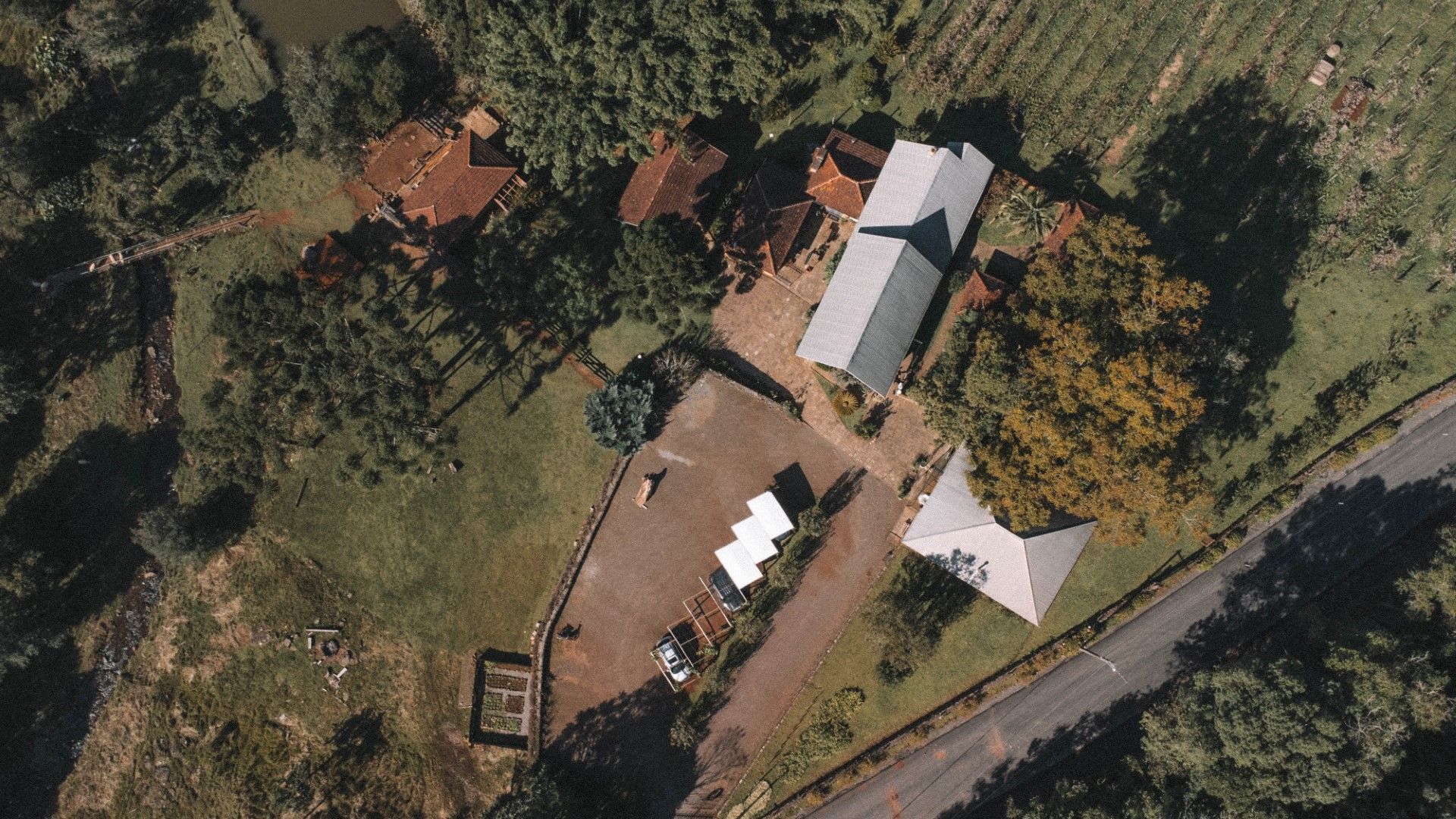 Vista aérea de edifícios, cercados por árvores verdes e uma estrada.