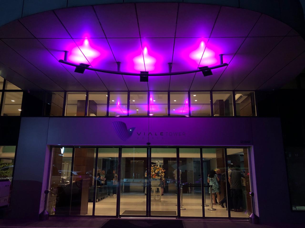Fachada do Hotel Viale Tower iluminada com tons de cor-de-rosa como apoio ao combate ao câncer de mama
