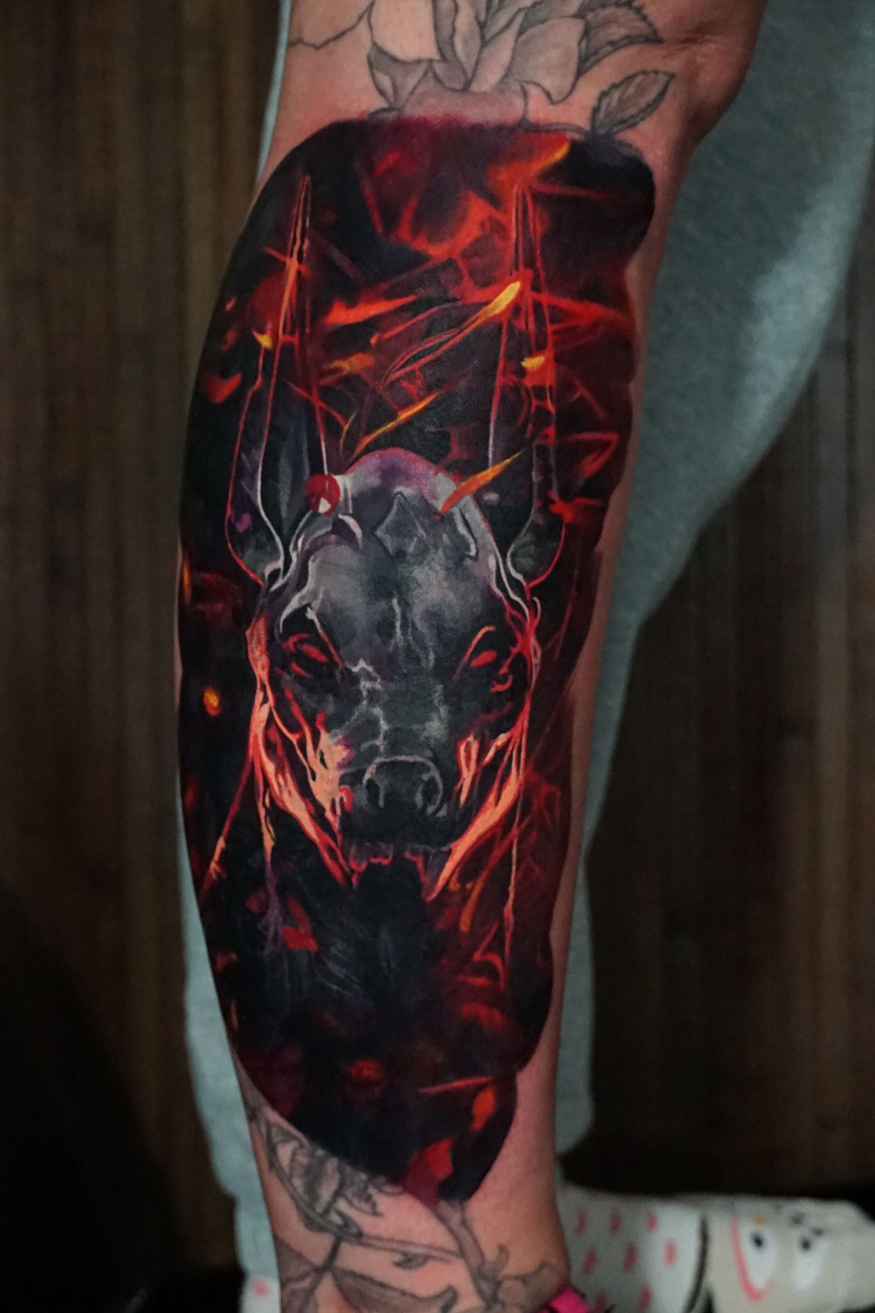 A person has a tattoo of a dog on their leg.