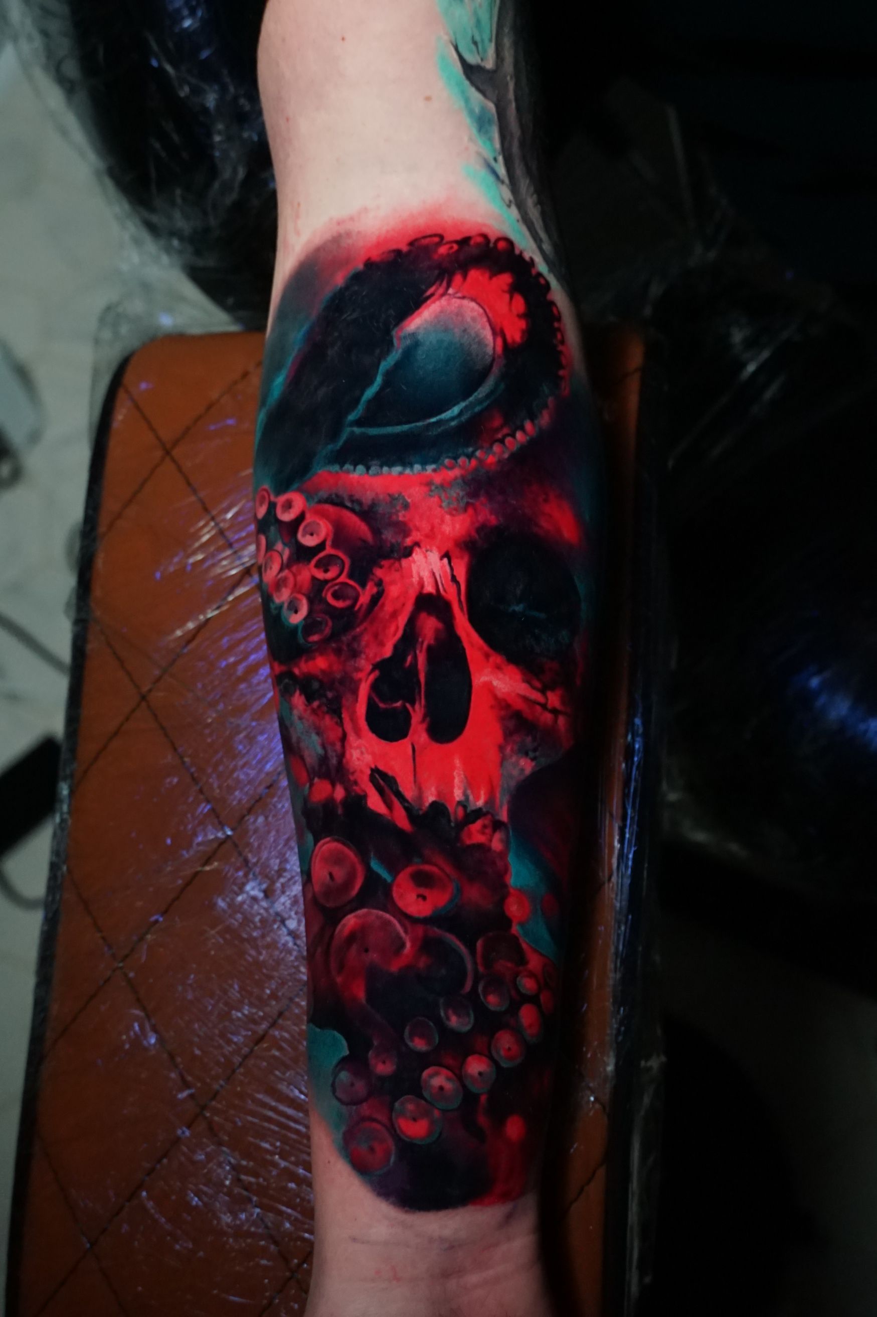 A colorful tattoo of a skull and octopus on a person 's arm.