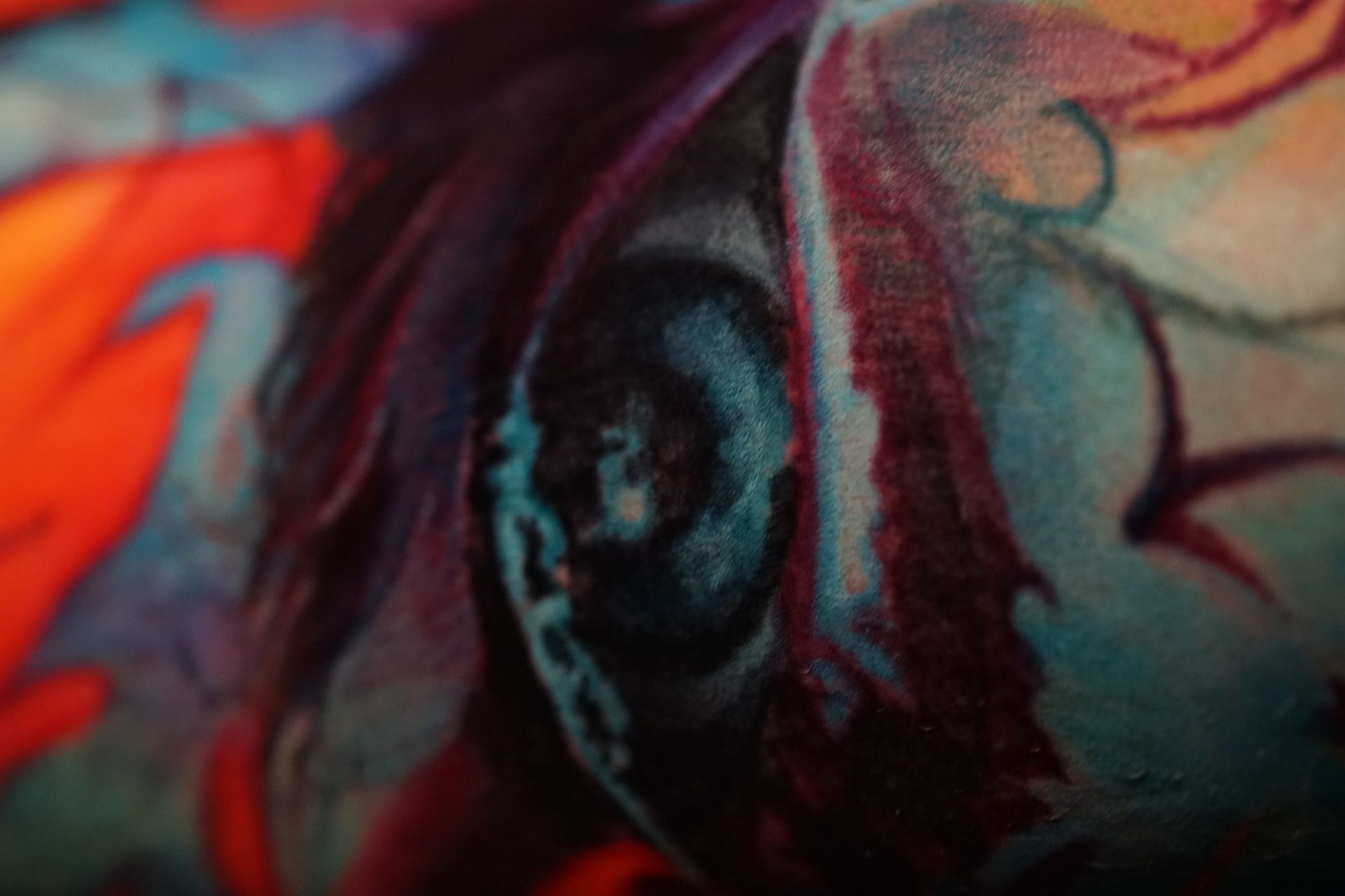 A close up of a colorful painting of a woman 's face.