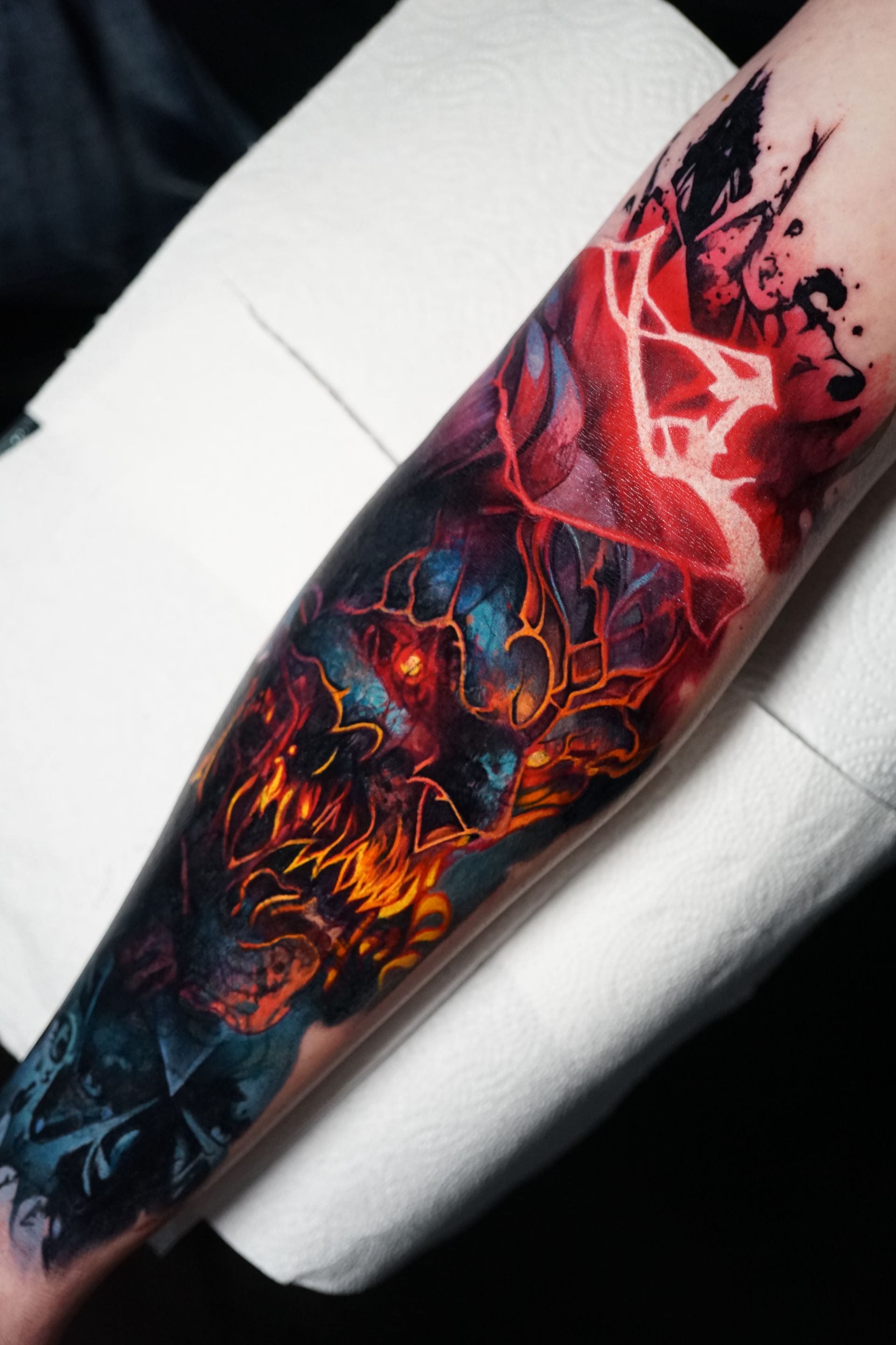 A person has a tattoo on their forearm that looks like a painting.