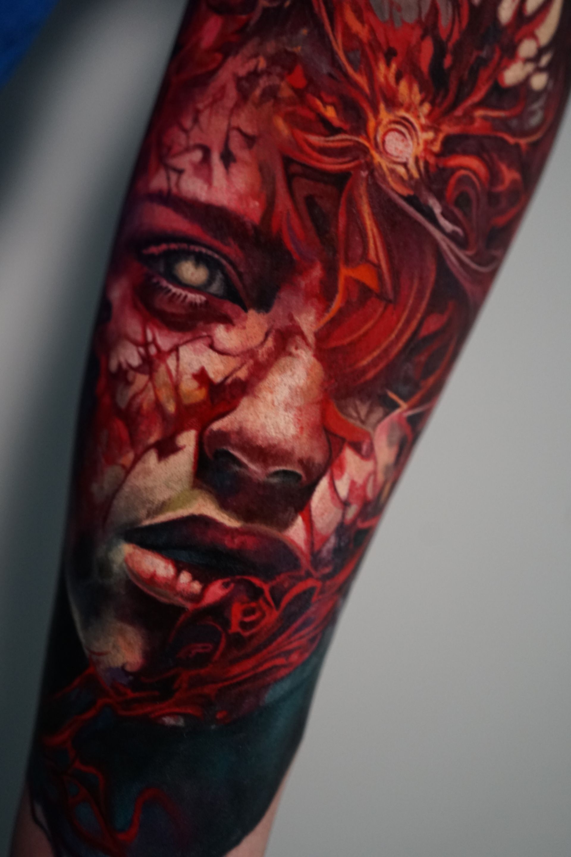 A close up of a tattoo of a woman 's face on a forearm.