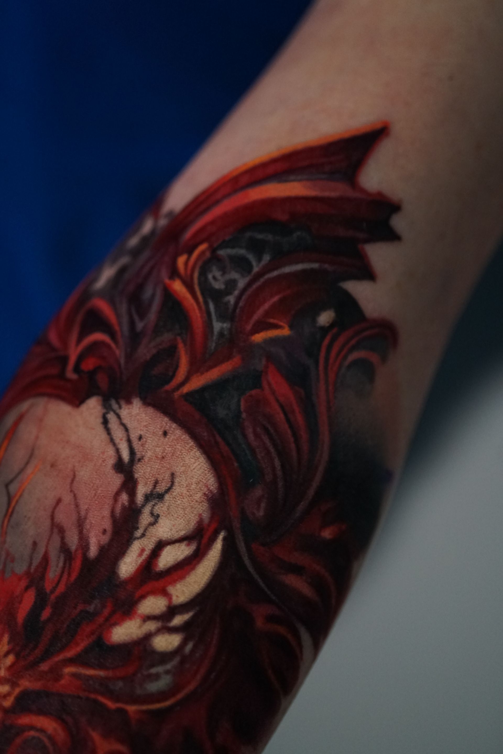 A person has a tattoo of a dragon on their arm.