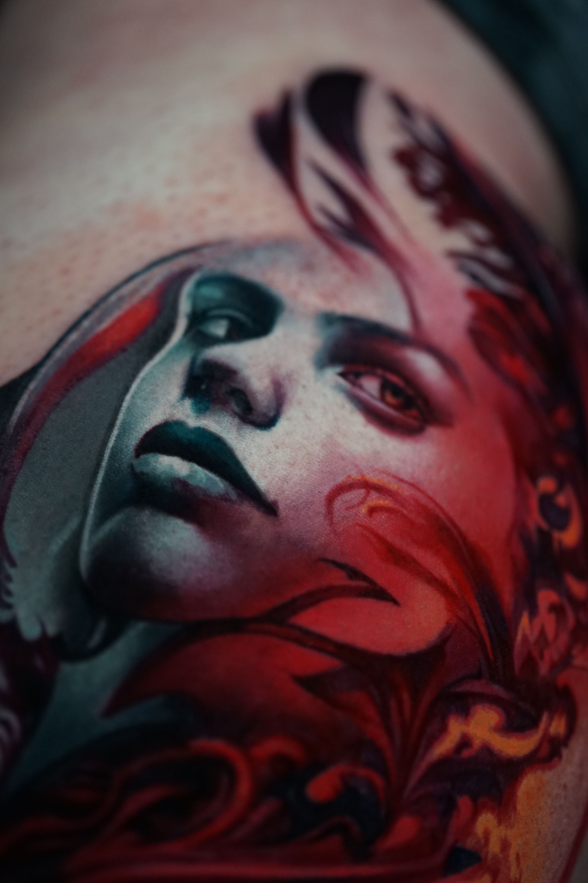 A close up of a tattoo of a woman 's face on a person 's arm.