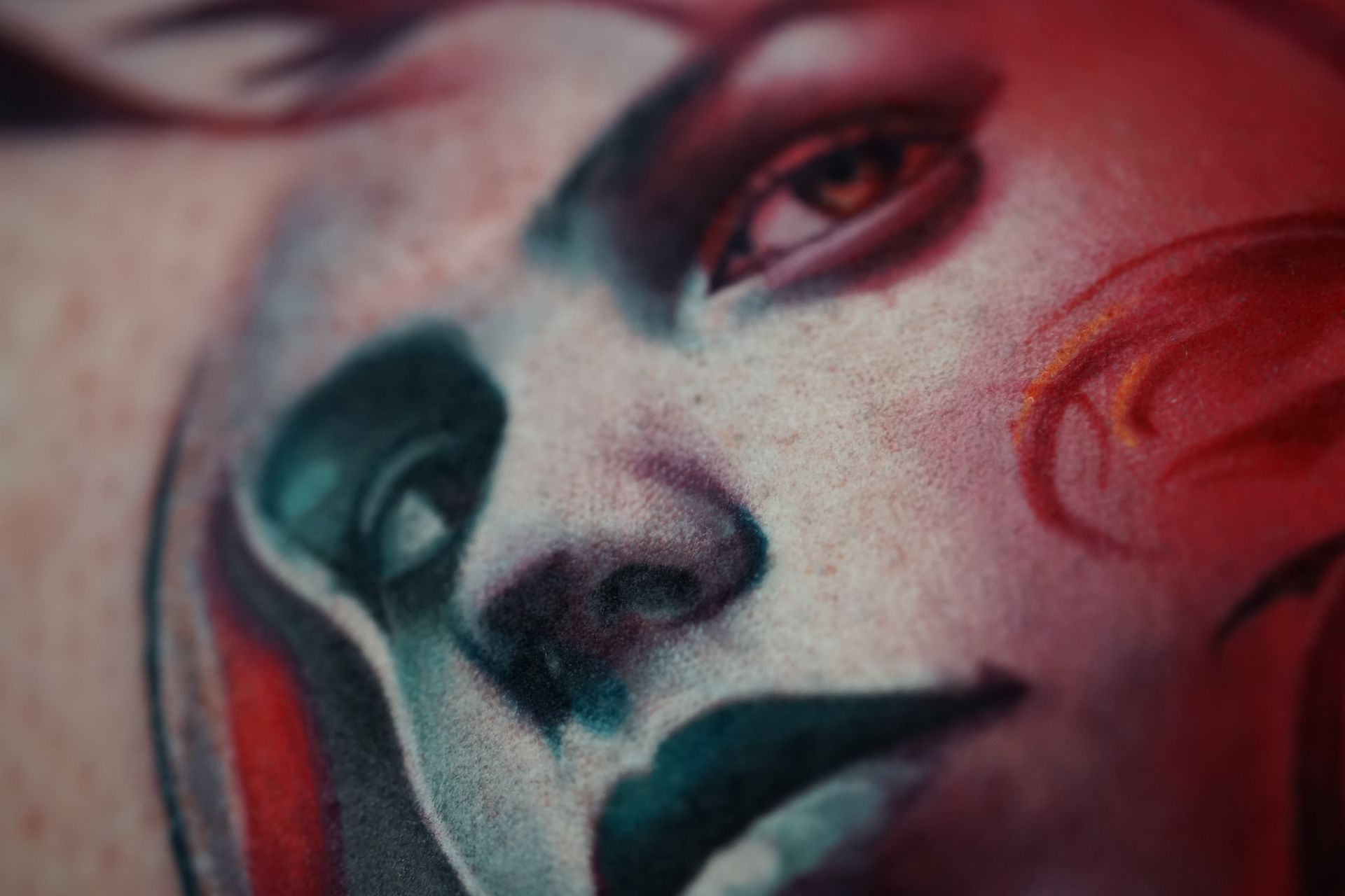 A close up of a tattoo of a woman 's face on a person 's arm.
