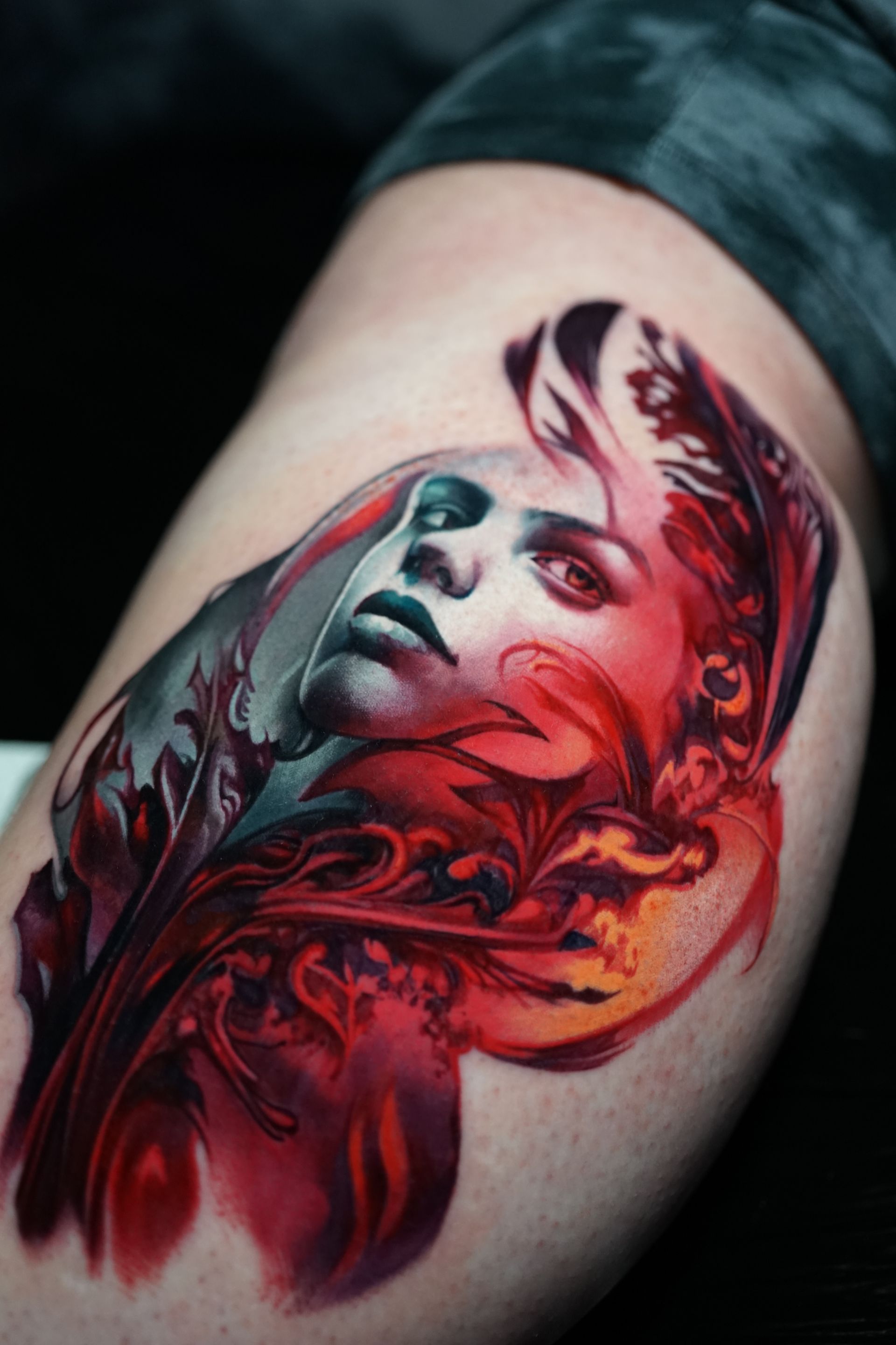 A colorful tattoo of a woman 's face on a person 's leg.