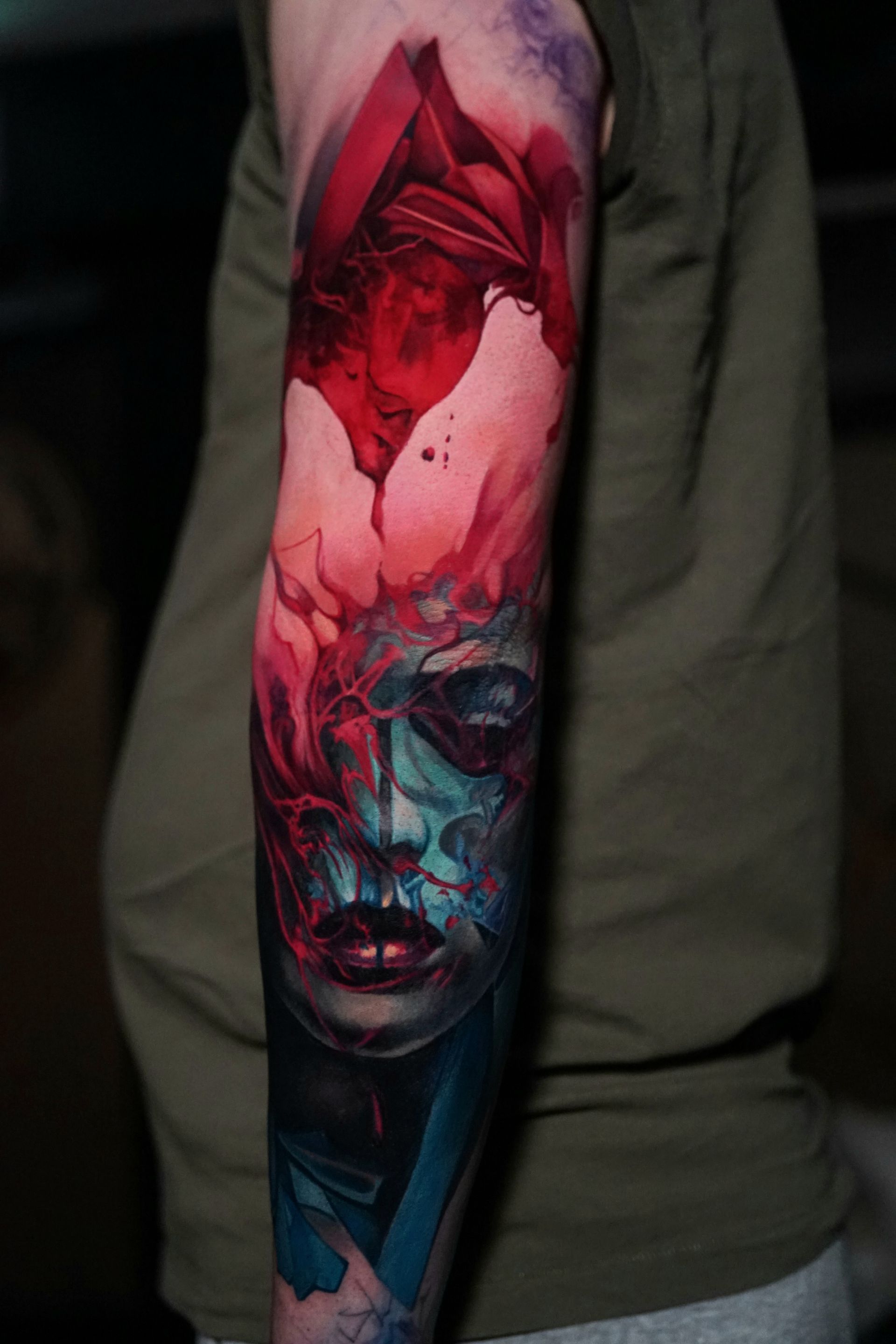 A person has a colorful tattoo of a woman 's face on their arm.