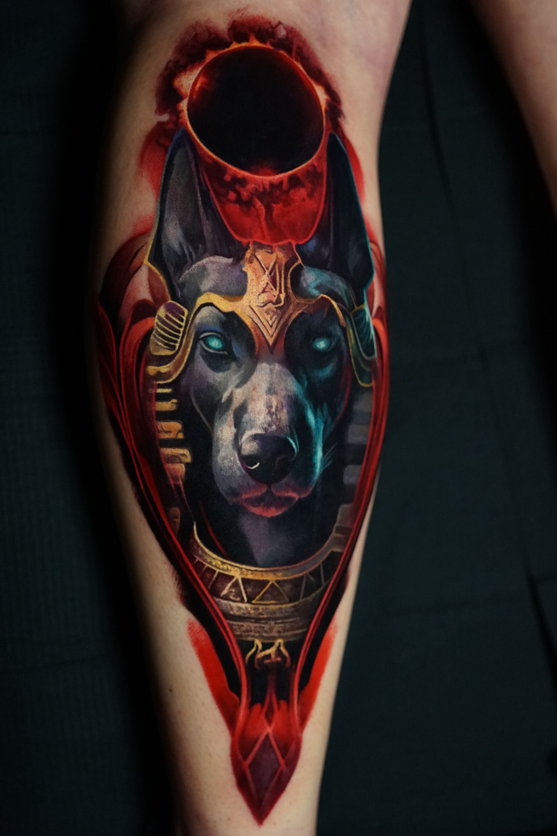 A person has a tattoo of a dog wearing a helmet on their leg.