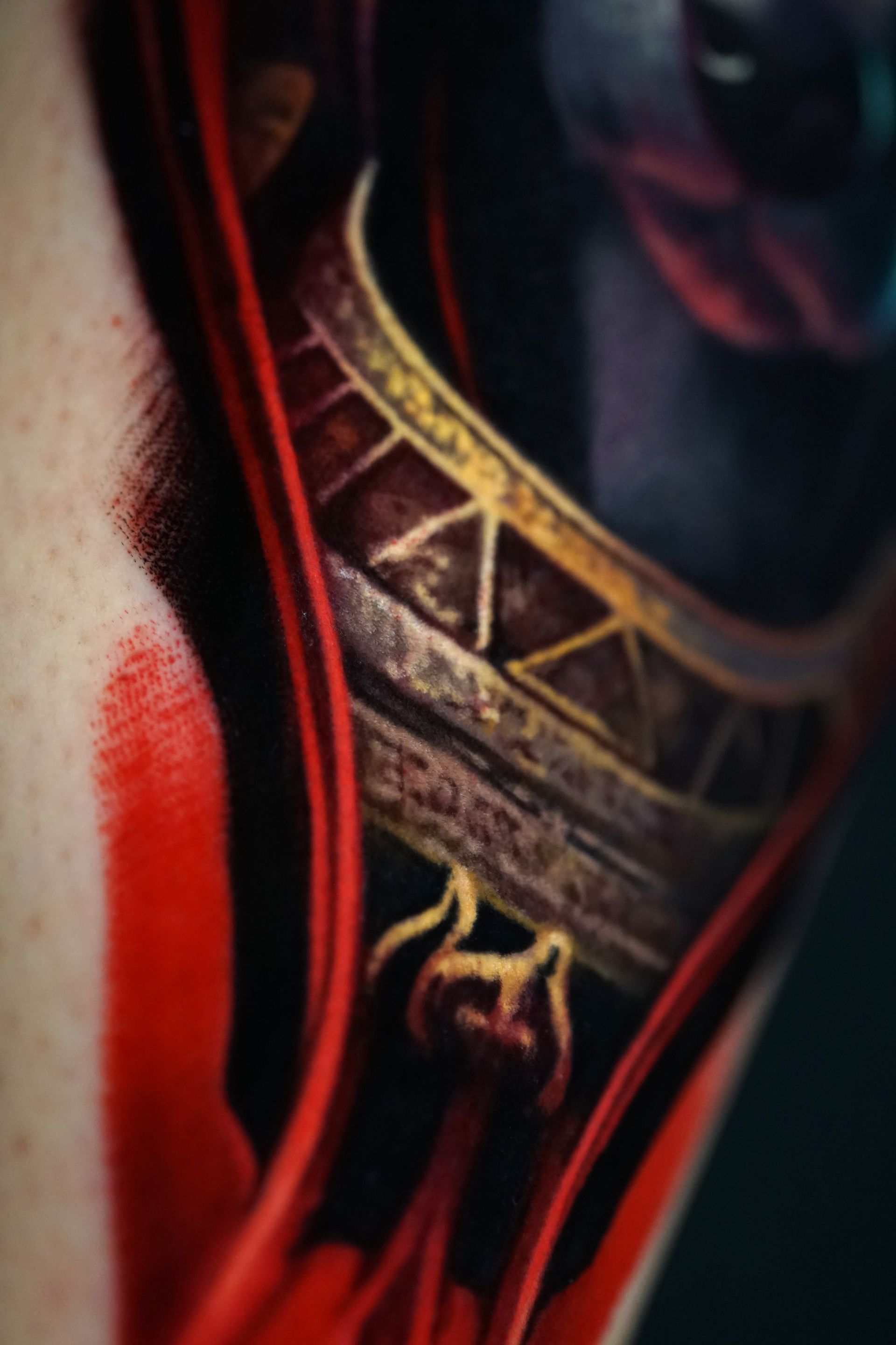 A close up of a person wearing a red and gold necklace